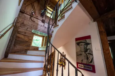 a staircase in a house with a painting of a man at Kronplatz Ski Lodge in Valdaora