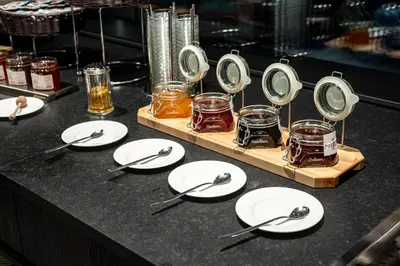 a table topped with white plates and silver utensils at Stella Hotel - My Dolomites Experience in Selva di Val Gardena