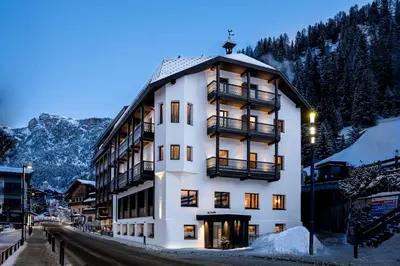 a large white building with a balcony at Stella Hotel - My Dolomites Experience in Selva di Val Gardena