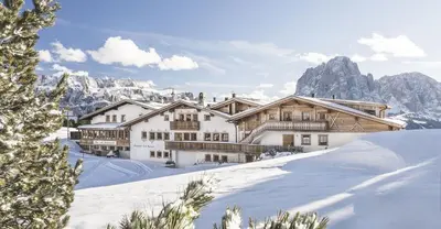 a ski lodge in the mountains with snow at Almhotel Col Raiser in Santa Cristina in Val Gardena