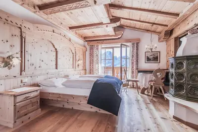 a bedroom with a large bed and a wooden ceiling at Almhotel Col Raiser in Santa Cristina in Val Gardena