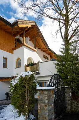 a house with a gate in the snow at B&B Frühlingsheim in Racines