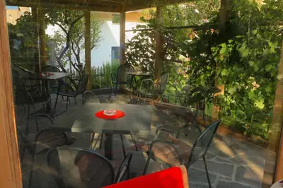 a patio with a table and chairs and a window at B&B Frühlingsheim in Racines