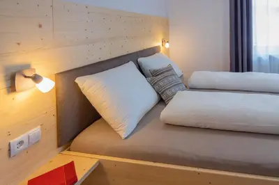 a room with two beds and a lamp and a table at B&B Frühlingsheim in Racines