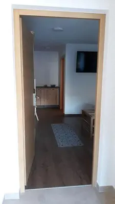 an open door to a living room with a television at B&B Frühlingsheim in Racines