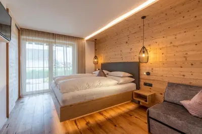 a bedroom with a large bed and a couch at Uetzenhof in Naz-Sciaves