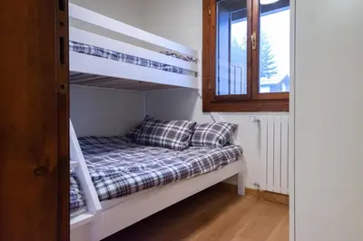 a bunk bed in a room with a bunk bed in a bedroom at Chalet Ruoibes in San Vito di Cadore