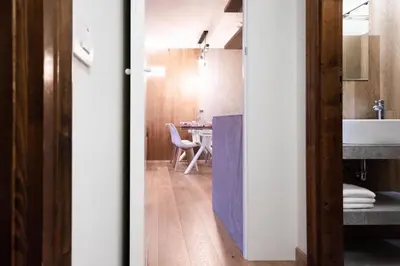 a room with a bathroom with a sink and a table at Chalet Ruoibes in San Vito di Cadore