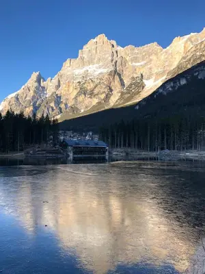 a mountain reflecting in a body of water at Chalet Ruoibes in San Vito di Cadore
