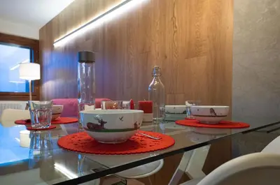a glass table with bowls and cups on top of it at Chalet Ruoibes in San Vito di Cadore