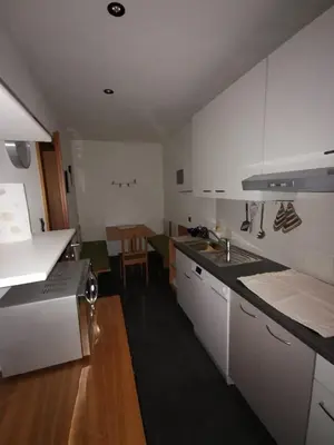 a kitchen with white cabinets and a sink and a table at Hörtmairhof in Campo Tures