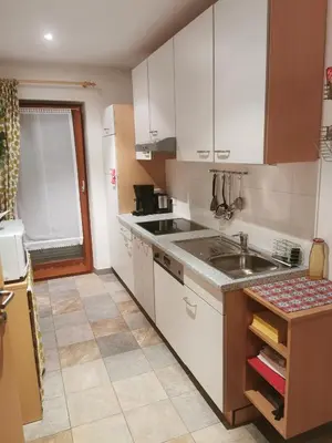 a kitchen with white cabinets and a sink at Hörtmairhof in Campo Tures