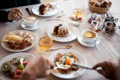 a table with plates of food and cups of coffee at Ebnerhof in Appiano sulla Strada del Vino