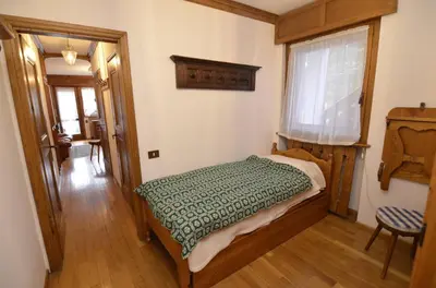 a bedroom with a bed and a window at Punta Nera: appartamento con giardino e WIFI in Zuel