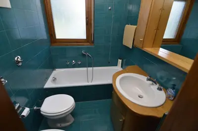 a bathroom with a toilet and a sink and a tub at Punta Nera: appartamento con giardino e WIFI in Zuel