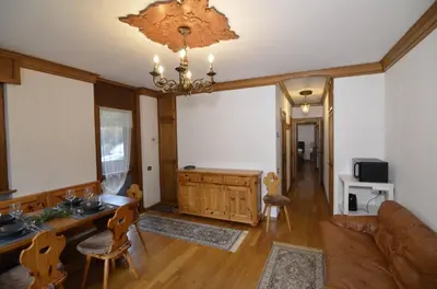 a living room with a couch and a chandelier at Punta Nera: appartamento con giardino e WIFI in Zuel
