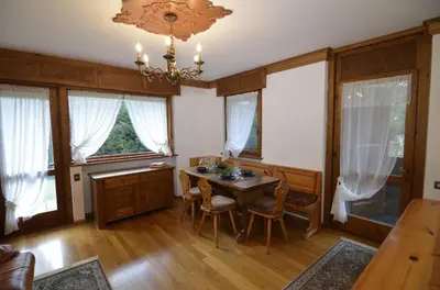 a dining room with a table and a chandelier at Punta Nera: appartamento con giardino e WIFI in Zuel