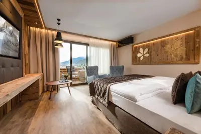 a hotel room with a bed and a table and chairs at MONDI Hotel Tscherms in Cermes