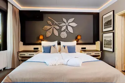 a bedroom with a large bed with blue and white pillows at MONDI Hotel Tscherms in Cermes