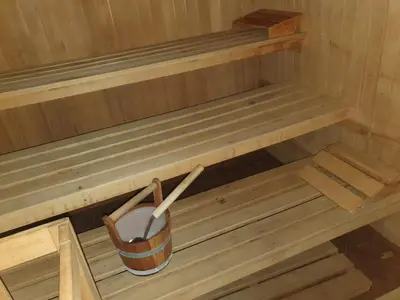 a small wooden sauna with a bucket in it at Chalet Hotel Diamant in San Martino in Badia
