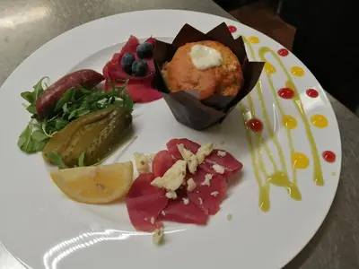 a white plate of food on a table at Chalet Hotel Diamant in San Martino in Badia