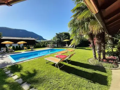 a swimming pool with two chairs and a table at Hirschenhof in Laives