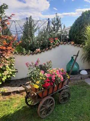 a wheelbarrow filled with flowers in a garden at Hirschenhof in Laives