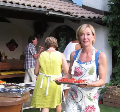 a woman holding a plate of food on a table at Hirschenhof in Laives