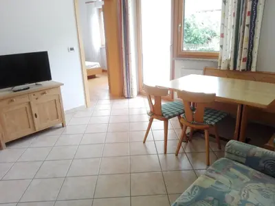 a living room with a table and a tv at Rabland Haus Texel I in Parcines