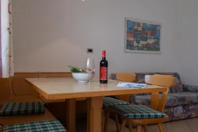 a table with a bottle of wine and a glass at Rabland Haus Texel I in Parcines