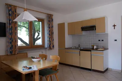 a kitchen with a table and a dining room at Ferienwohnung im Haus Texel II in Parcines
