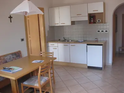 a kitchen with a wooden table and a table and chairs at Ferienwohnung im Haus Texel IV in Parcines