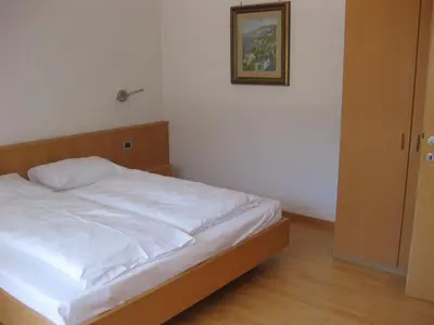 a bed in a bedroom with a picture on the wall at Ferienwohnung im Haus Texel IV in Parcines