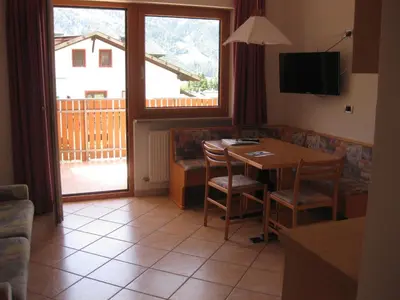 a living room with a table and chairs and a large window at Ferienwohnung im Haus Texel IV in Parcines