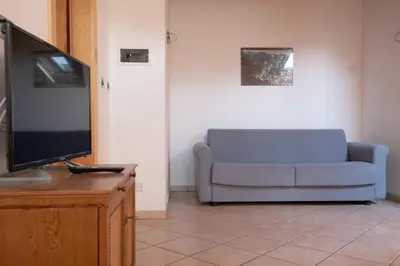 a living room with a couch and a flat screen tv at Ferienwohnung im Haus Texel VI in Parcines