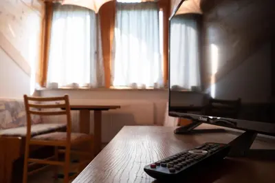 a remote control sitting on a wooden table with a television at Ferienwohnung im Haus Texel VI in Parcines