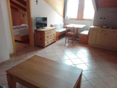 a room with a kitchen with a table and a bedroom at Ferienwohnung im Haus Texel VII in Parcines