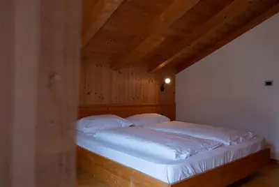 a bed with white sheets and pillows in a room at Ferienwohnung im Haus Texel VII in Parcines