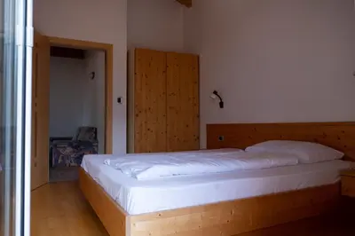 a bedroom with a large bed with a wooden headboard at Ferienwohnung im Haus Texel VII in Parcines