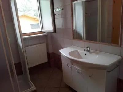 a bathroom with a sink and a mirror and a window at Ferienwohnung im Haus Texel VII in Parcines