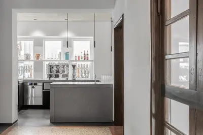 a kitchen with white cabinets and a gray island at Casa al Sole in Ortisei