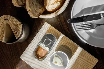 a table with a bowl of bread and a knife and fork at Casa al Sole in Ortisei