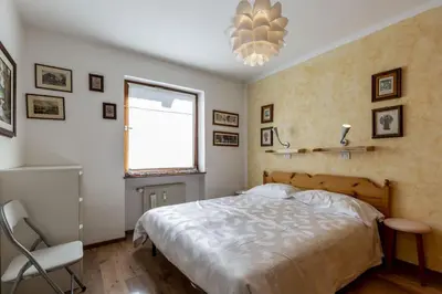 a bedroom with a bed and a window and a chandelier at Solaia in Mazzin