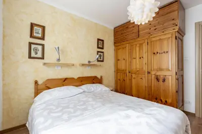 a bedroom with a bed and a wooden cabinet at Solaia in Mazzin
