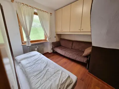 a small bedroom with a couch and a window at Solaia in Mazzin