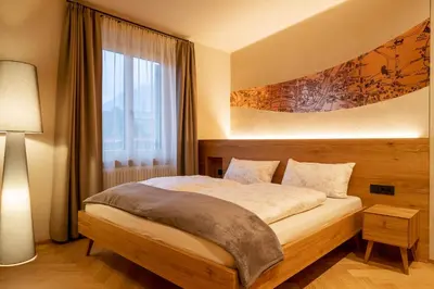 a bedroom with a bed and a large window at Ladurner Suites in Merano