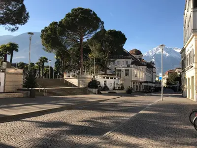 a street in a town with a mountain in the background at Ladurner Suites in Merano