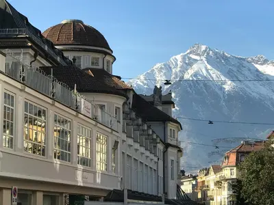 a building with a snow covered mountain in the background at Ladurner Suites in Merano