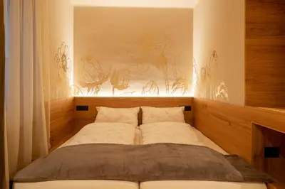 a bed in a room with a painting on the wall at Ladurner Suites in Merano