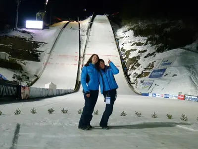 two people standing on a fence in the snow at B&BeautyFol Dolomites B&B adults only in Predazzo